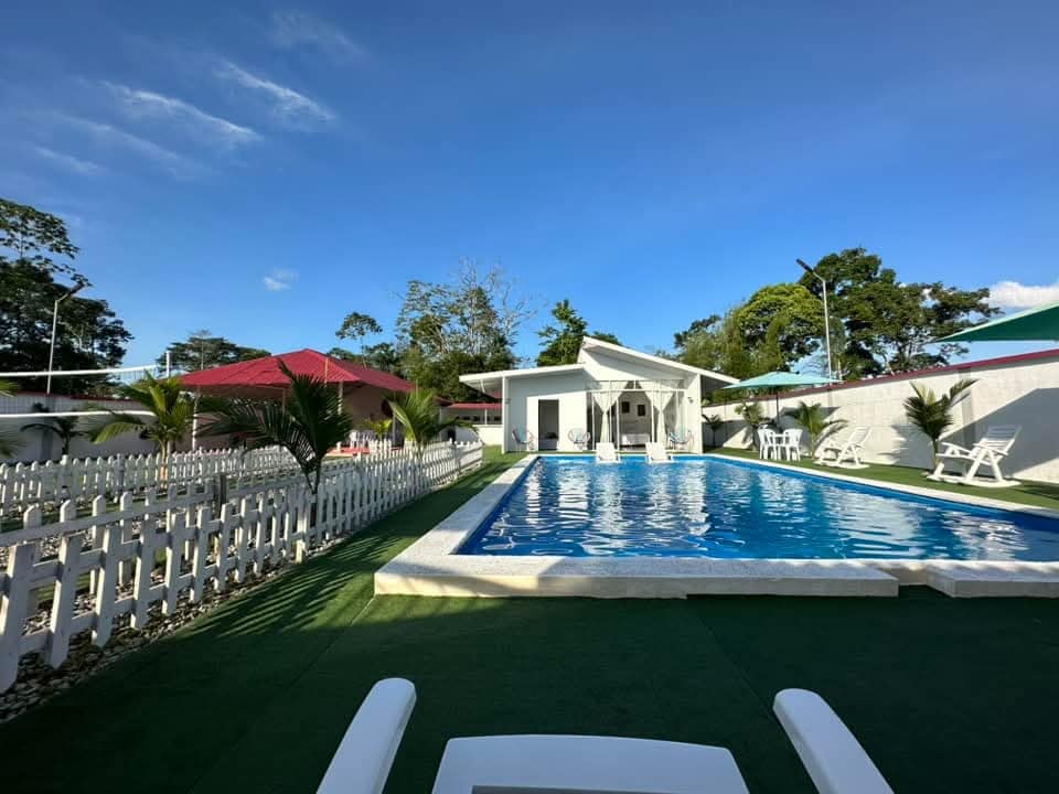 Foto de finca y piscina con cielo azul y pasto verde